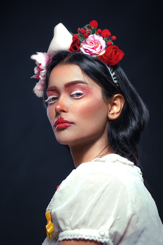 Creative portrait of a woman with floral headpiece and artistic makeup, showcasing elegance and fantasy.